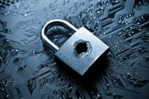 A security lock with a hole on computer circuitboard representing computer security breach encouraging workers to utilize cybersecurity